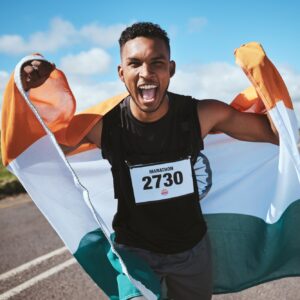 Celebration, portrait and man with flag of India or runner on a road in nature for success in race,