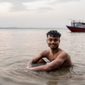 Indian man sitting on the water of the Ganges river